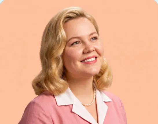 A smiling woman with set blonde hair and pearls